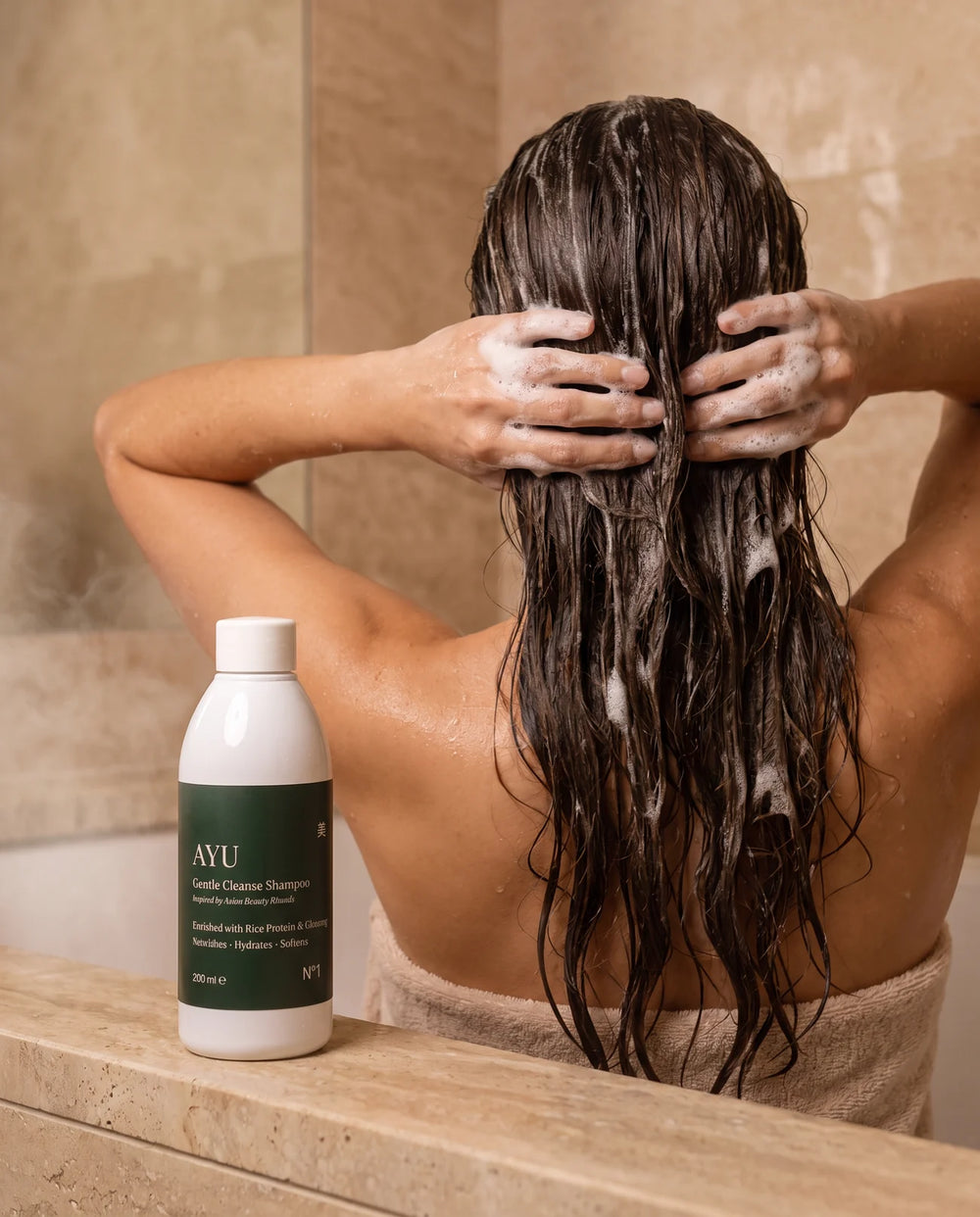 Shampooing AYU massé dans les cheveux sous la douche